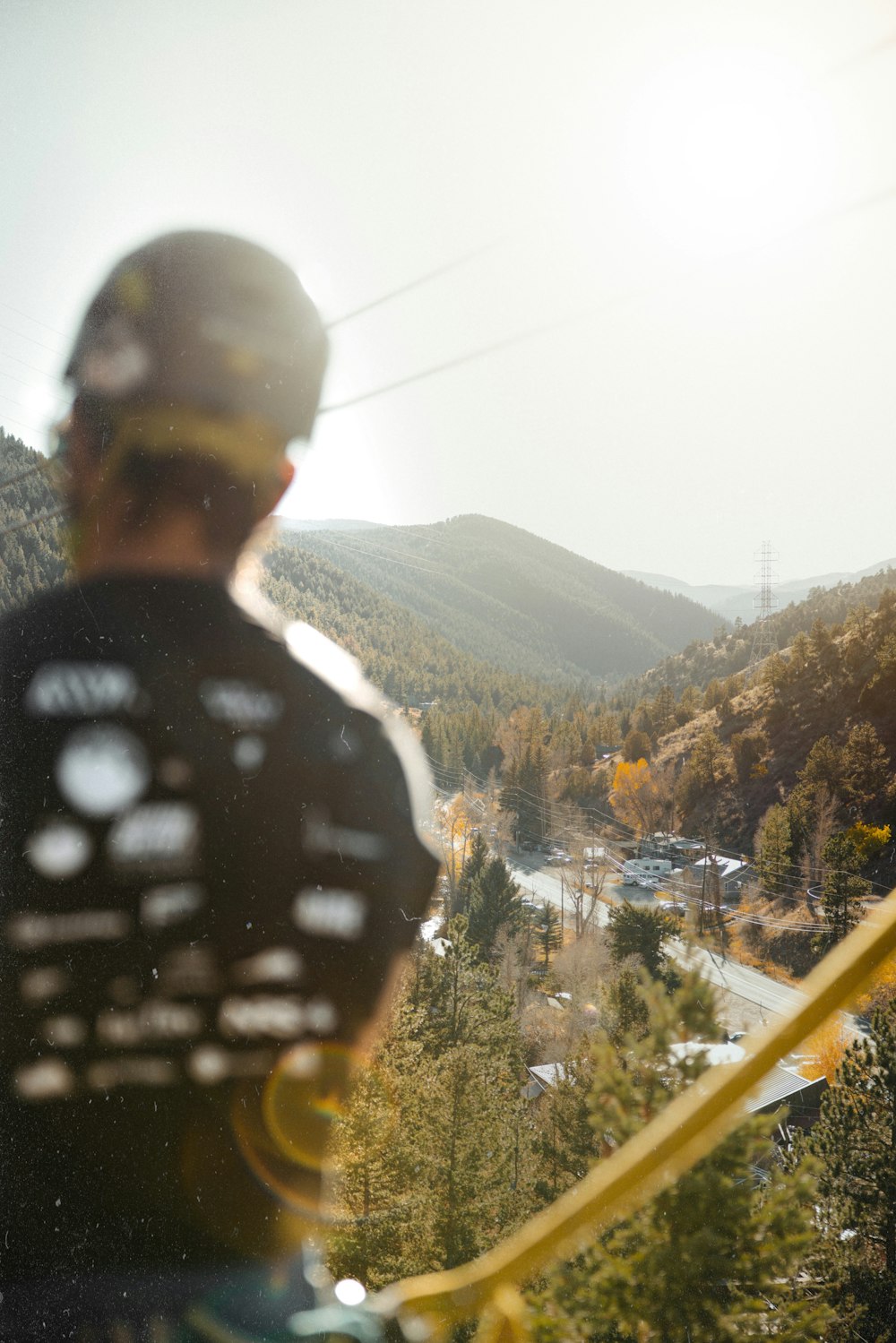 a man standing on top of a hill next to a forest