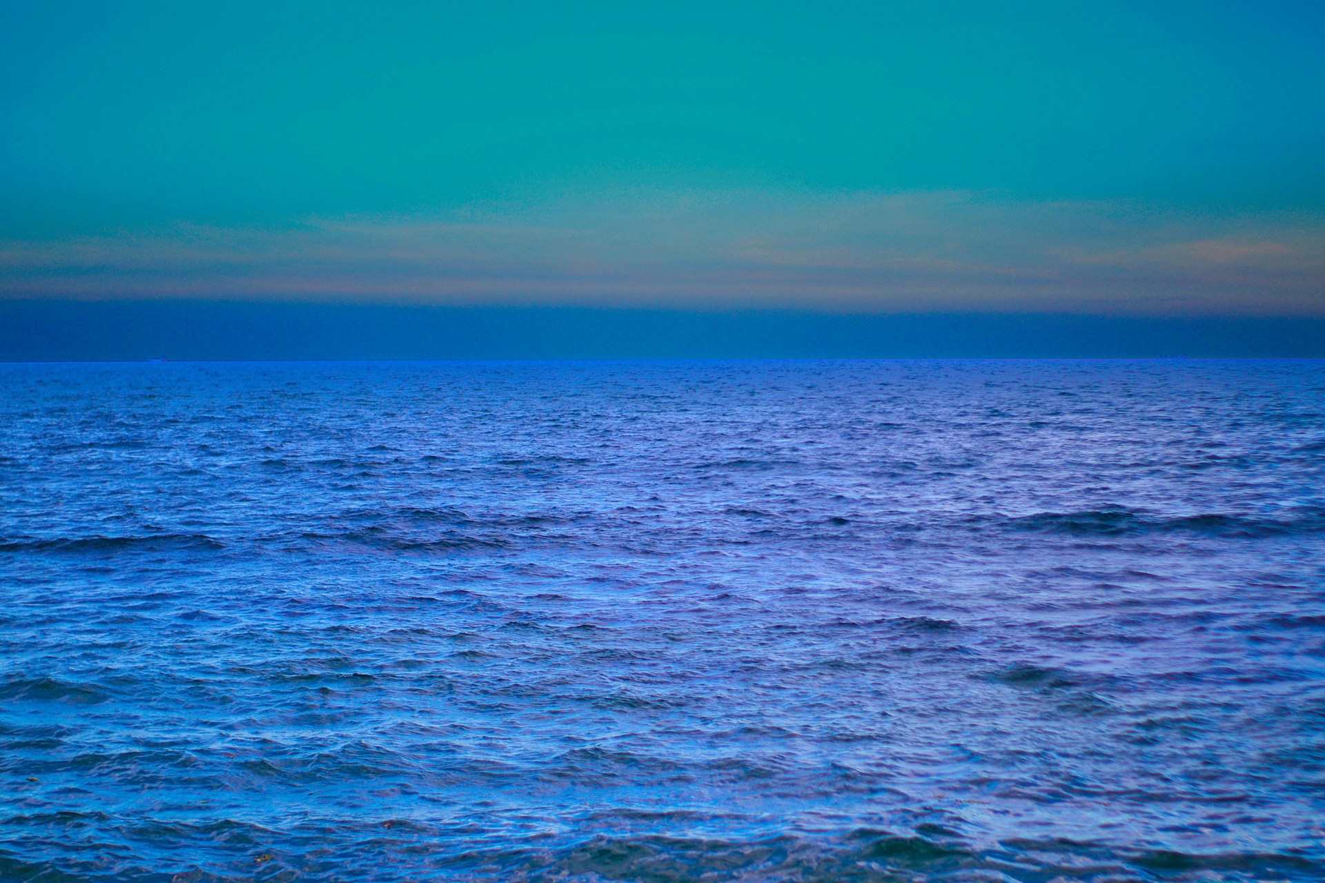 a large body of water with a sky in the background