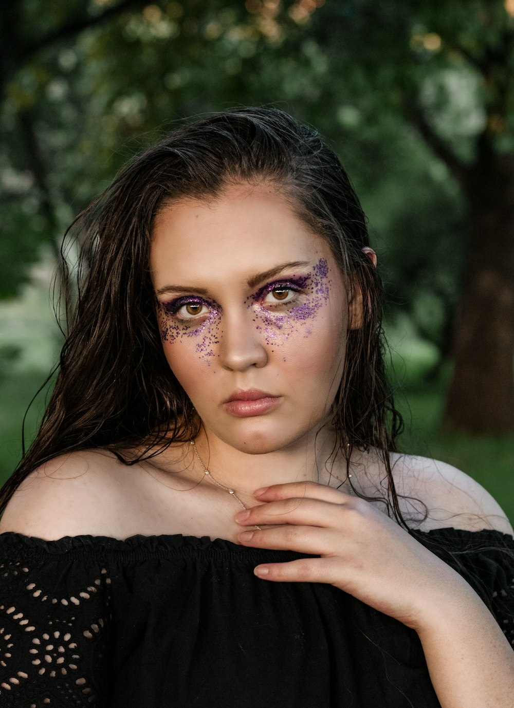 a woman with purple makeup and a black dress
