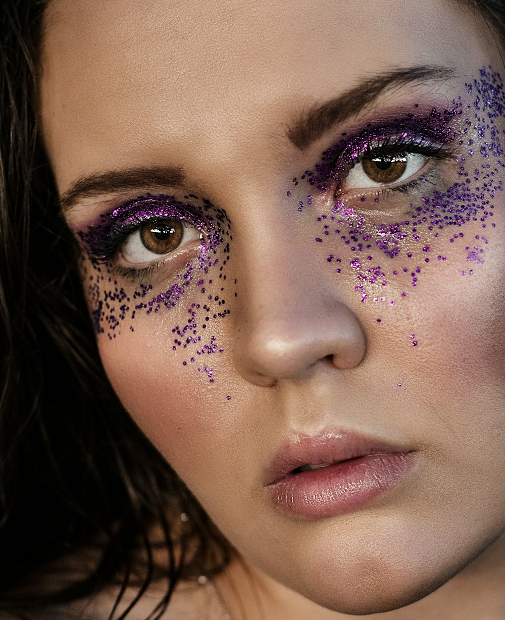 a woman with purple glitter on her face