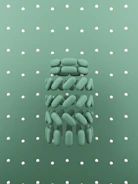 Array of mint-green and desert tan oral pouches arranged on a rugged surface suggesting durability and precision