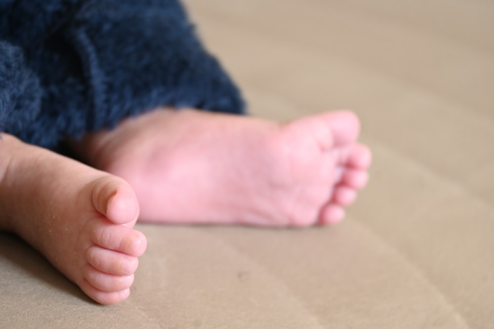 a close up of a baby's foot on a bed