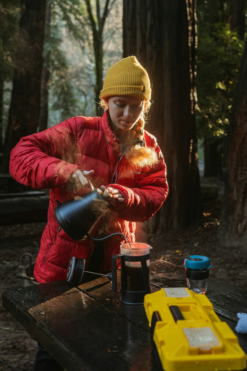 a person pouring something into a cup on a table