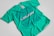 A turquoise t-shirt with an intricate blue graphic design and text on the front. The design includes various abstract shapes, musical elements, and patterns. The text reads 'New Breed of Deep House' with additional words above it that are difficult to discern.