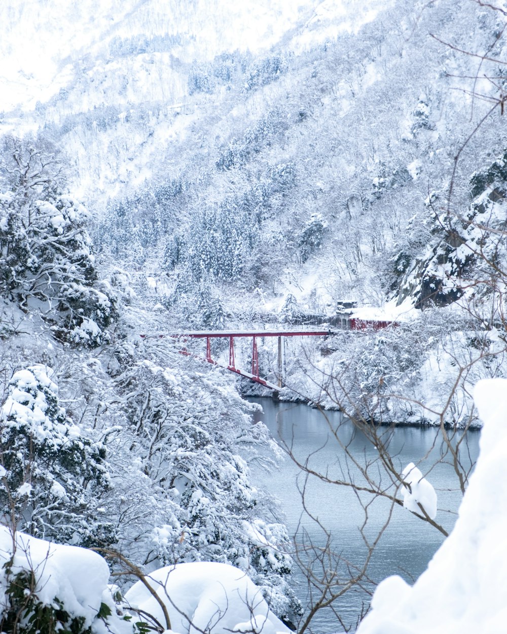 a bridge over a body of water surrounded by snow