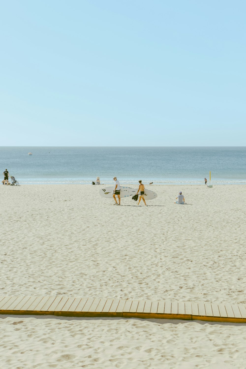 a group of people walking across a sandy beach