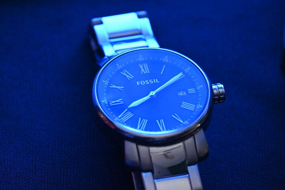 a close up of a watch on a blue surface