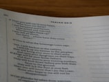 A close-up of a page from a Bible, specifically from the book of Isaiah, displaying verses with heading numbers at the top. The text is printed in black on an off-white page with blue chapter headings.