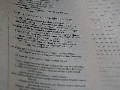 A close-up view of a page from a book, displaying text with a style consistent with biblical scripture. The text is in a clear, serif font, organized into numbered sections with verses aligned on the left. Dotted lines fill the right side of the page, likely intended for notes or comments.