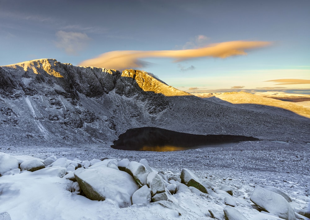 a snow covered mountain with a lake in the foreground