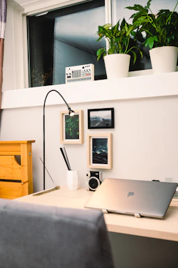 A sleek, modern workspace with a laptop, camera, and red accents reflecting a professional audiovisual studio environment