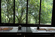 A serene Meiji Japan dining scene with delicate porcelain and ikebana flower arrangements.