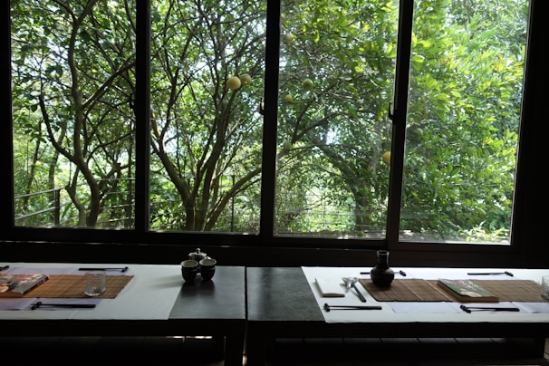 A serene dining table overlooking the Gulf of Thailand, styled with minimalist elegance in off-white and gold.