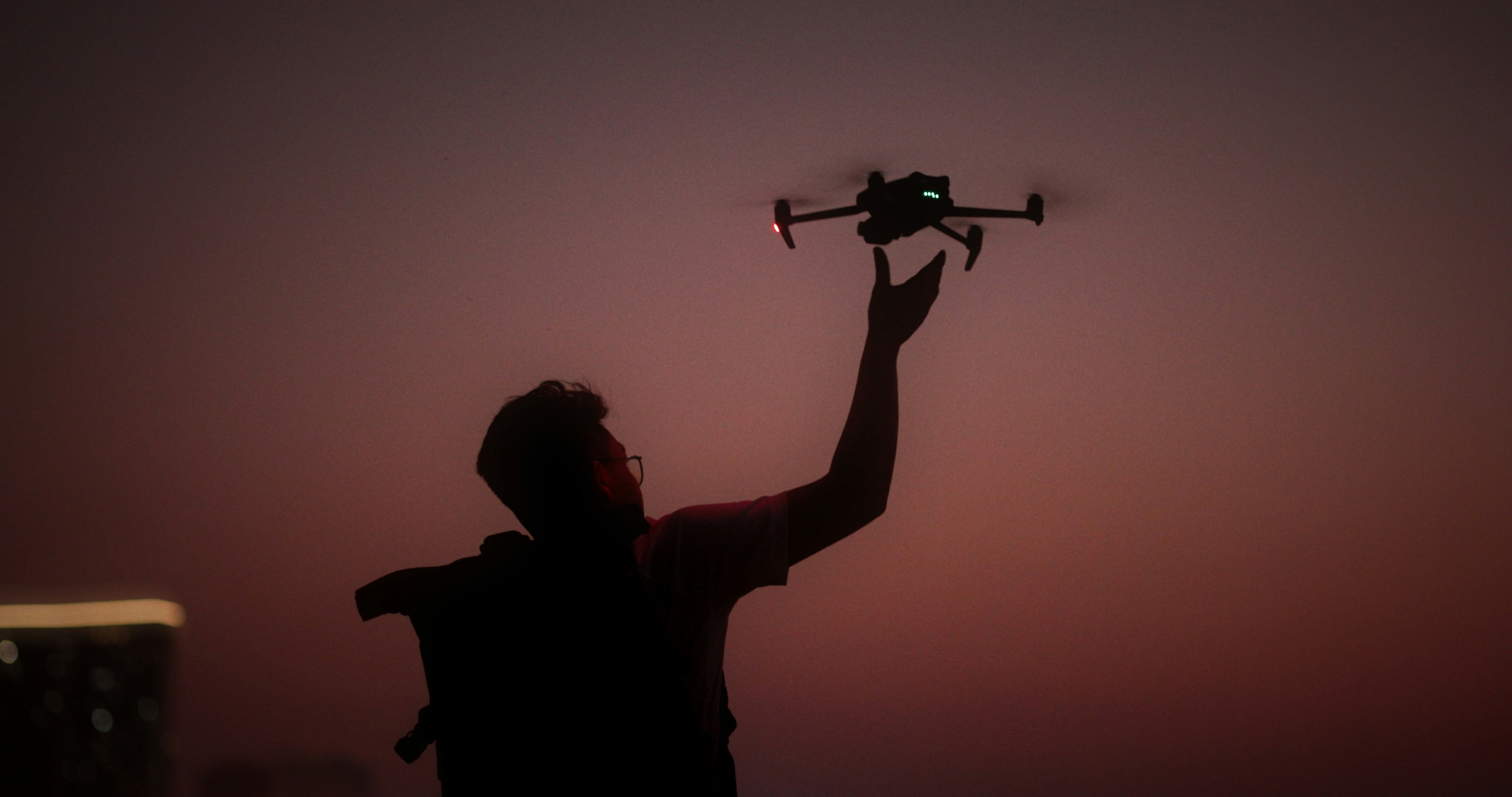 a man holding up a remote control plane in the air