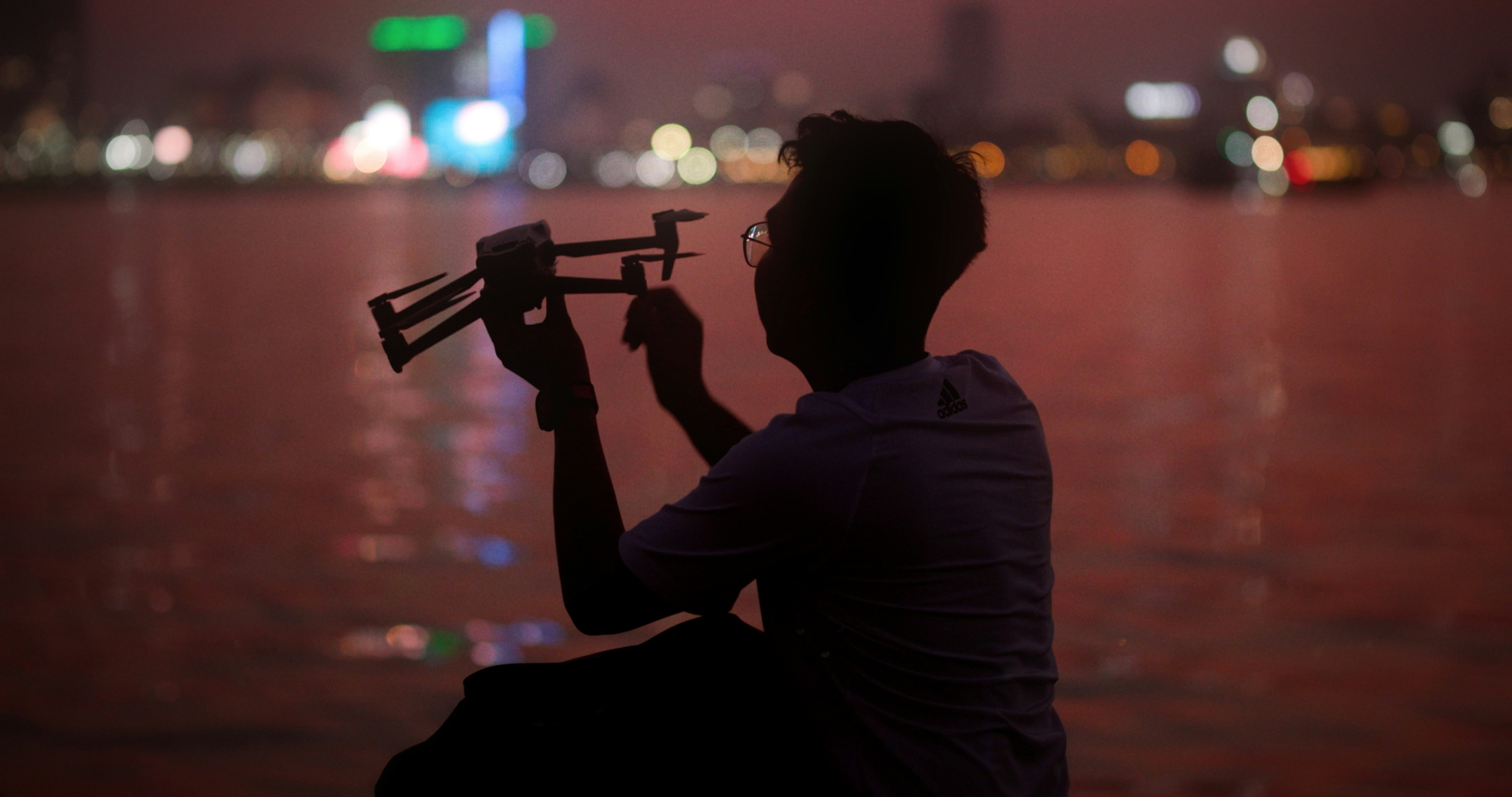 a man holding a toy airplane over a body of water
