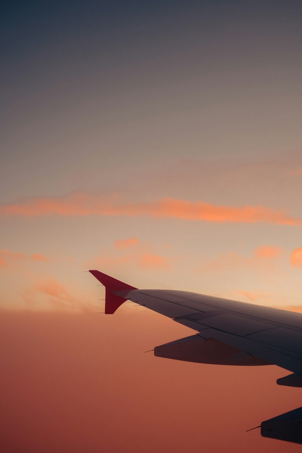 the wing of an airplane as the sun sets