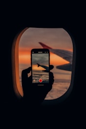 a person taking a picture of an airplane window