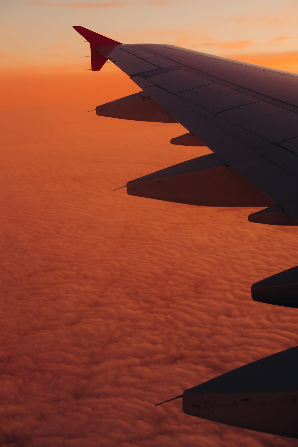 a view of the wing of an airplane at sunset