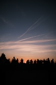 A serene sunset over a community gathering in nature.