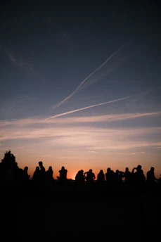 A heartfelt moment of community prayer during a peaceful outdoor gathering at sunset, symbolizing unity and faith.