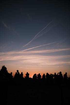 A serene sunset over a community gathering in nature.