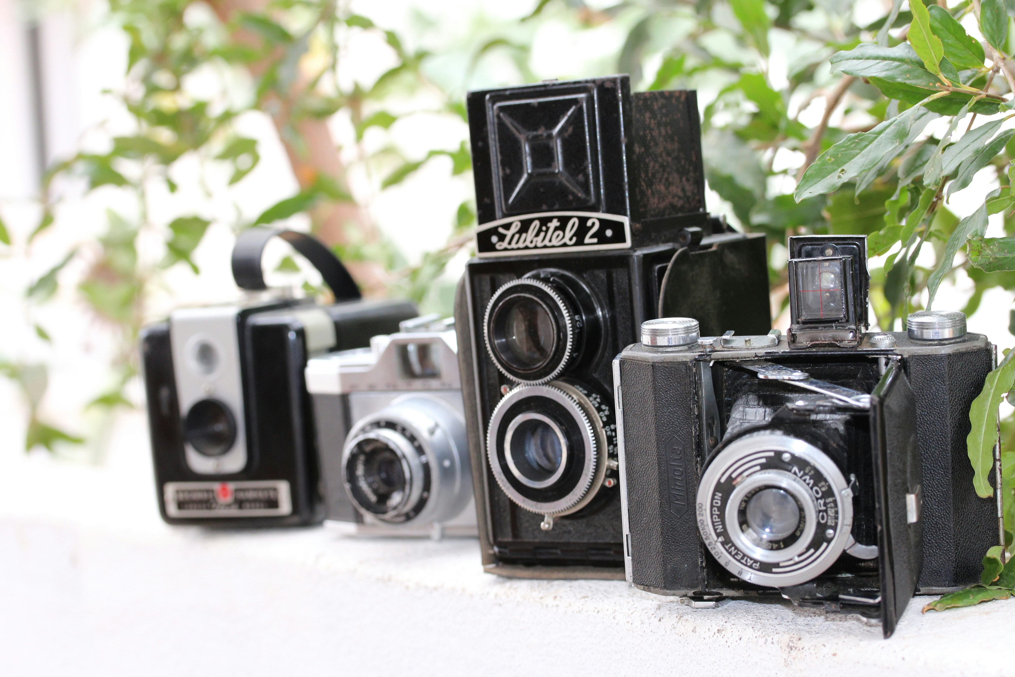 a row of old cameras sitting on top of a table