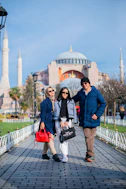 a man and two women standing in front of a building