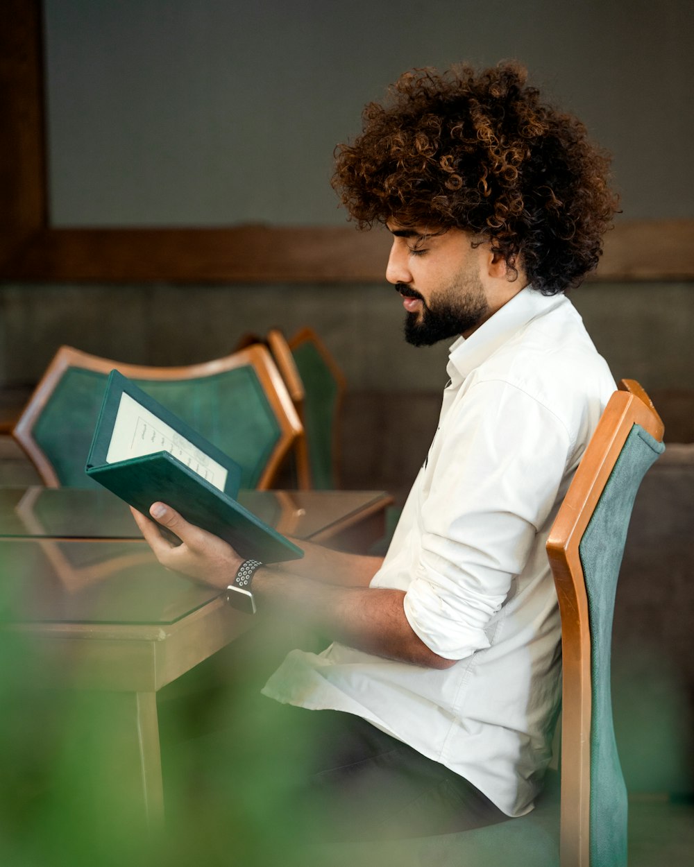 Un uomo seduto a un tavolo che legge un libro