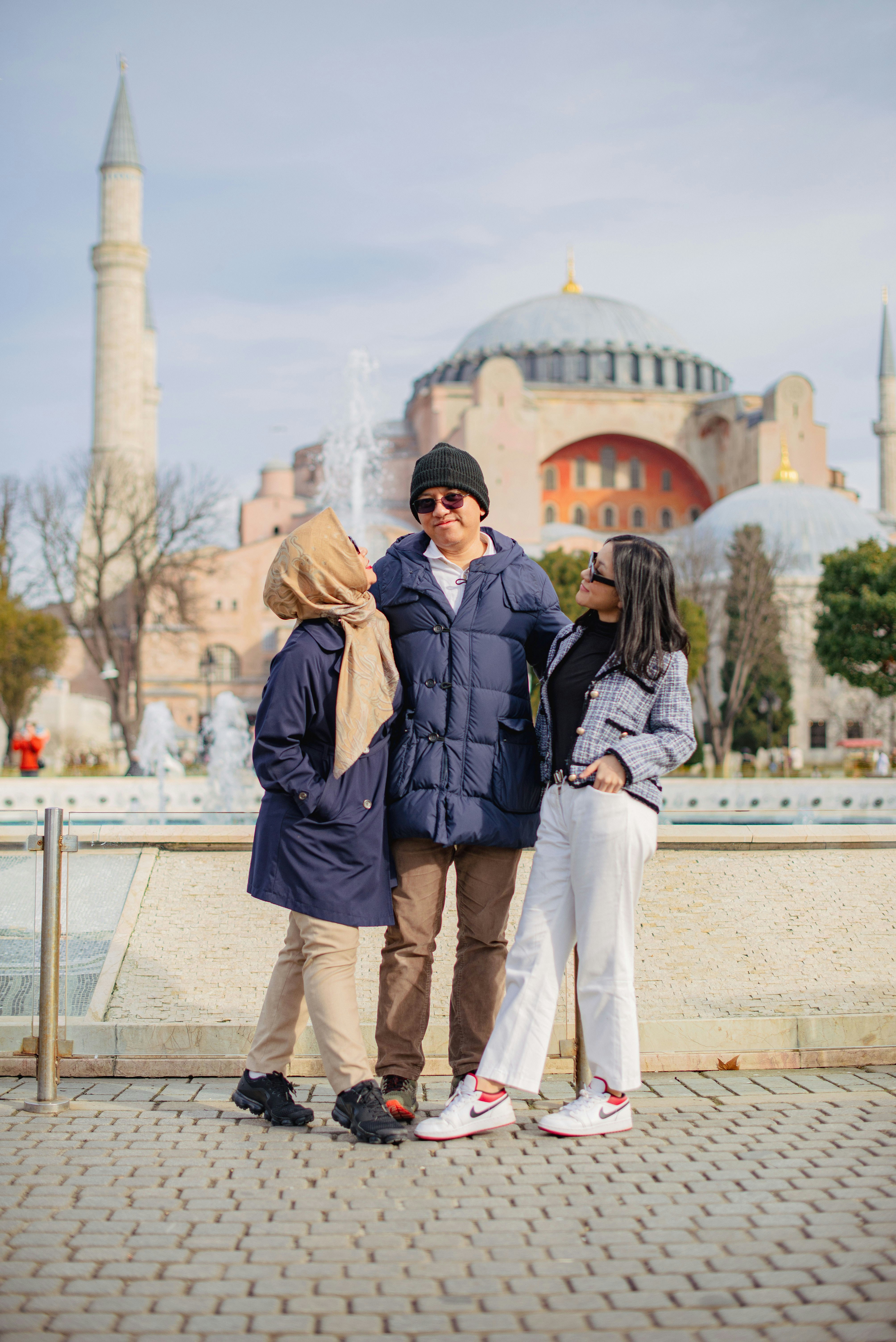 a man and two women standing in front of a fountain
