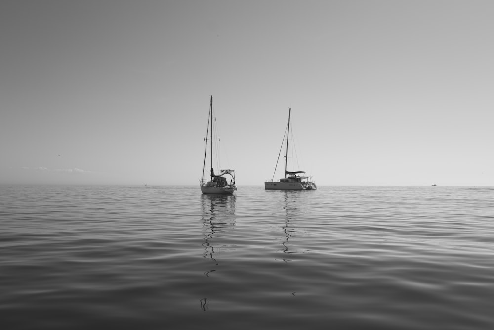 a couple of boats floating on top of a large body of water