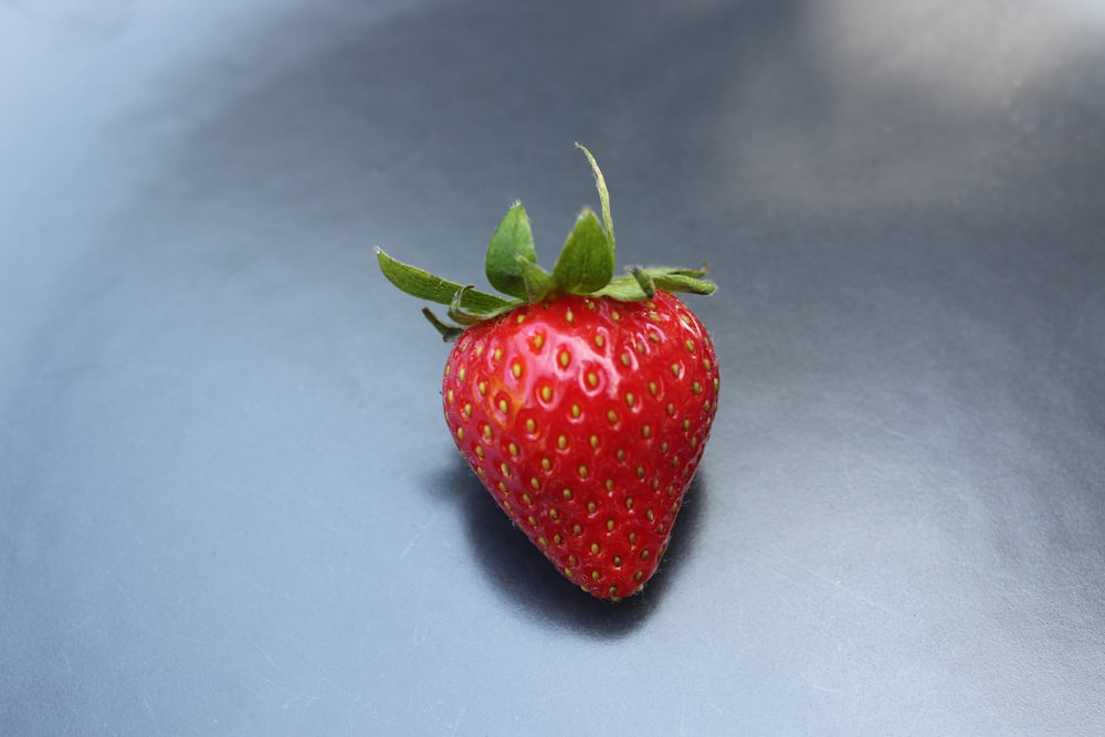 a close up of a strawberry on a blue surface
