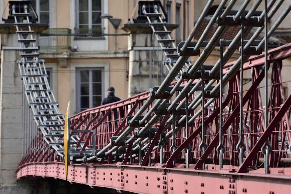 a red bridge with a man standing on top of it