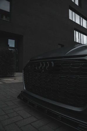 Close-up of a sleek supercar's aggressive front grille under moody lighting.