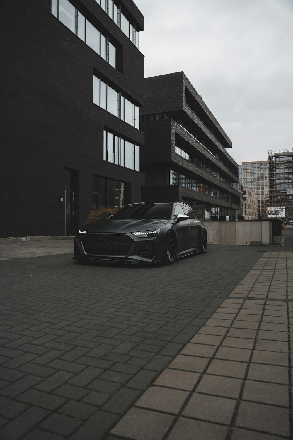 建物の前に駐車した黒いスポーツカー