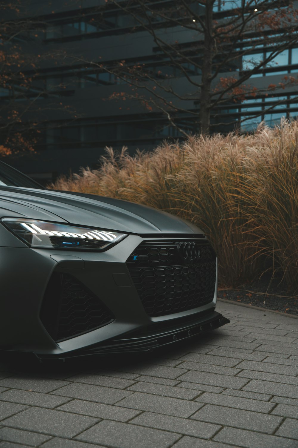 a grey car parked on a brick road