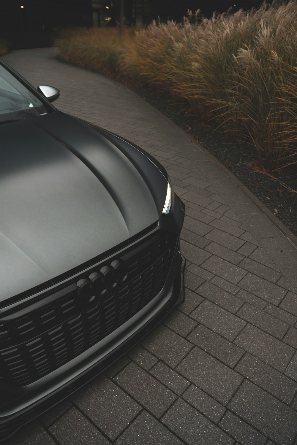 a close up of a car parked on a sidewalk