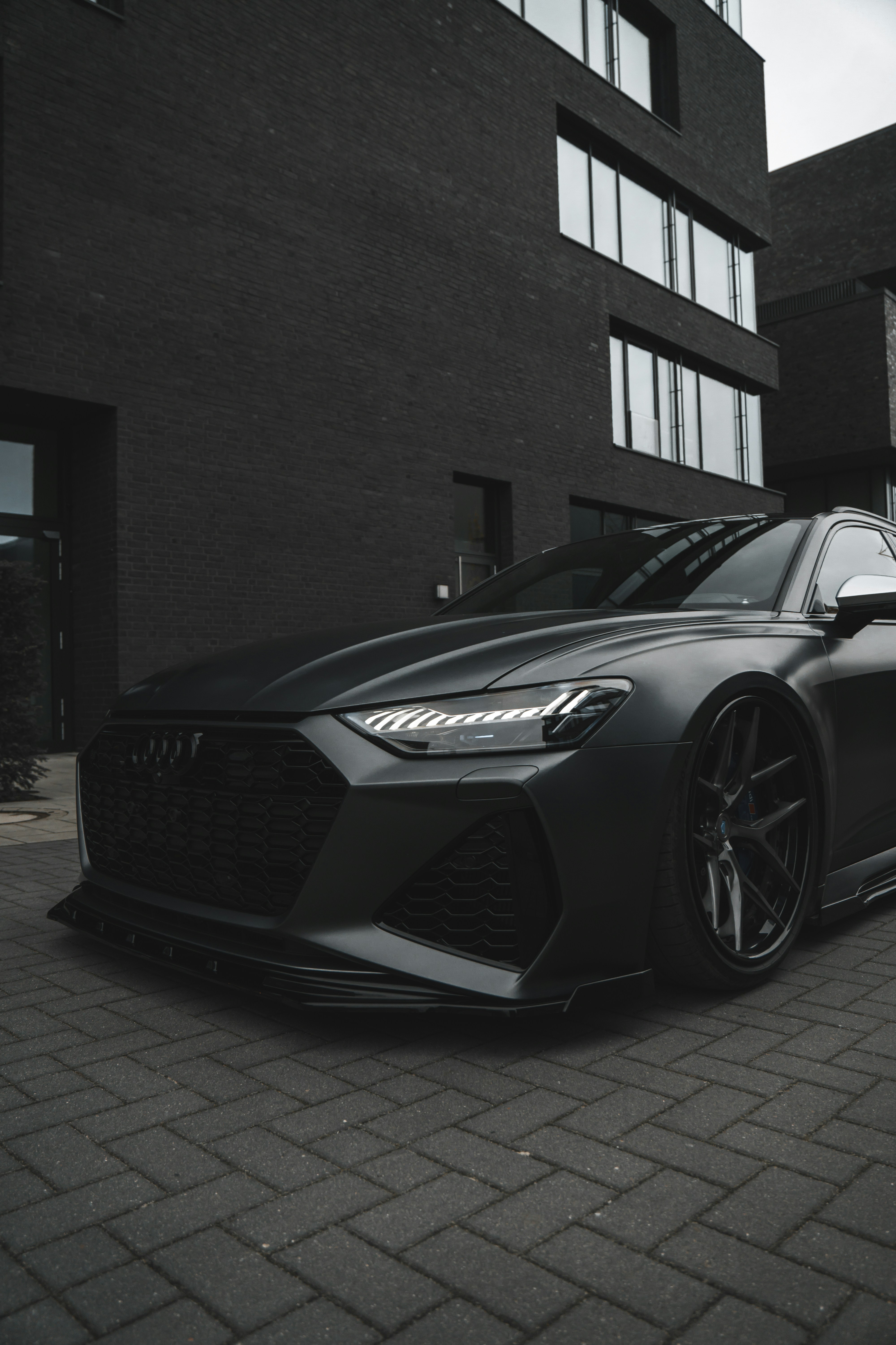 A black sports car parked in front of a building photo – Free Wallpaper  Image on Unsplash, image size:3000x4500