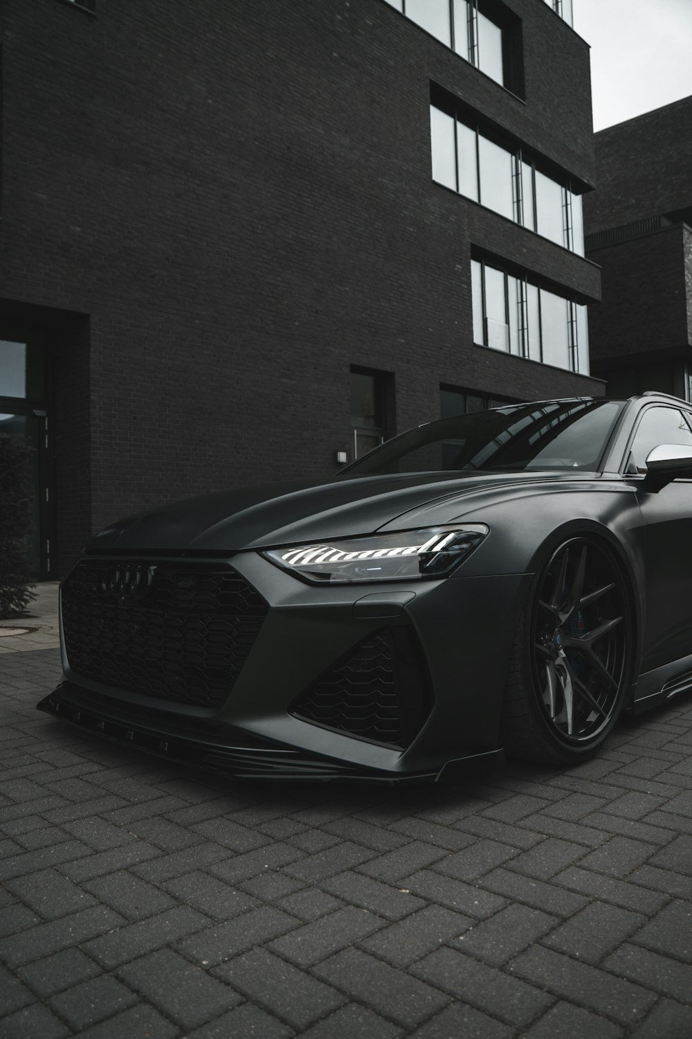 a black sports car parked in front of a building