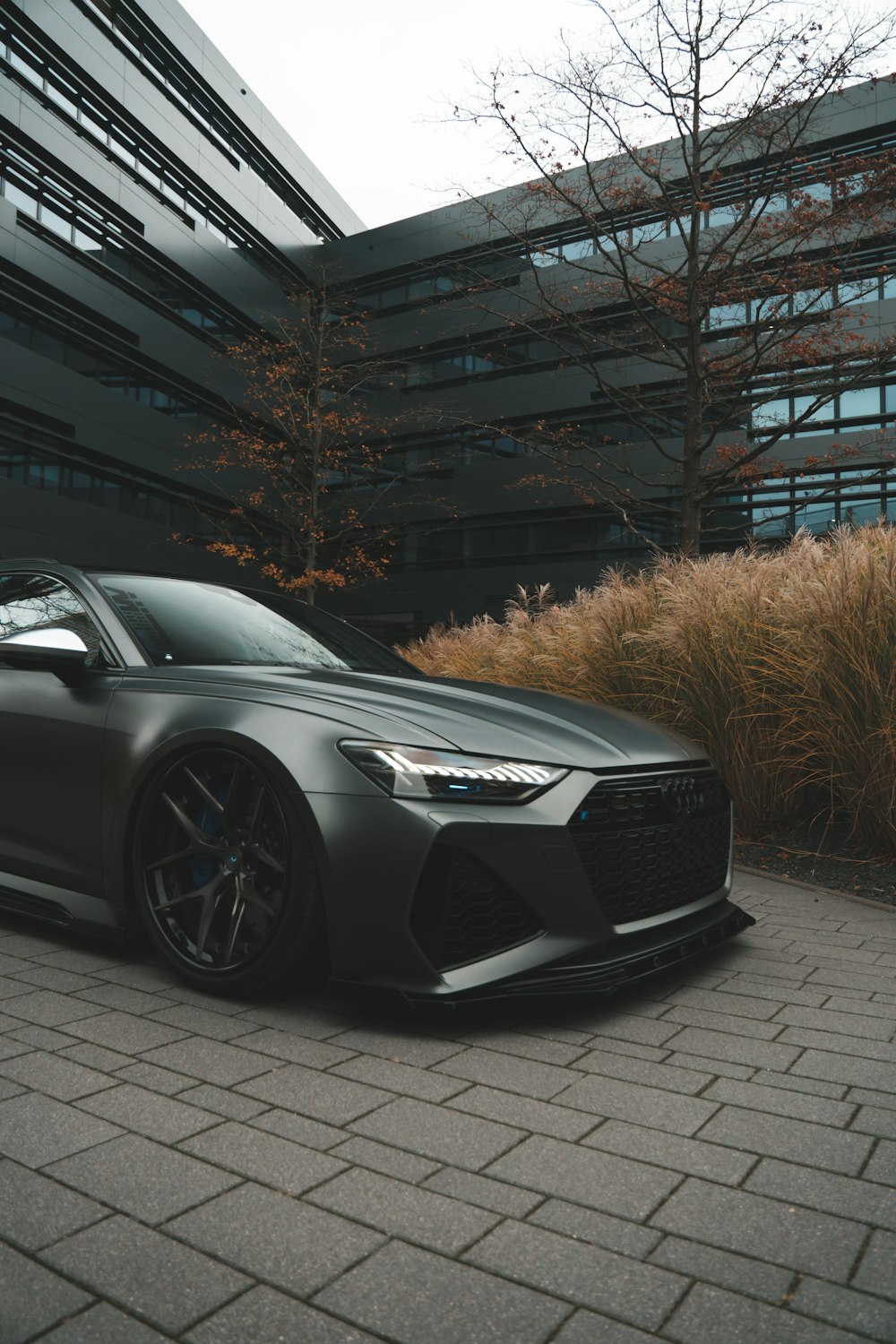 a grey car parked in front of a building