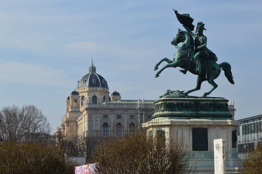 a statue of a man on a horse in front of a building