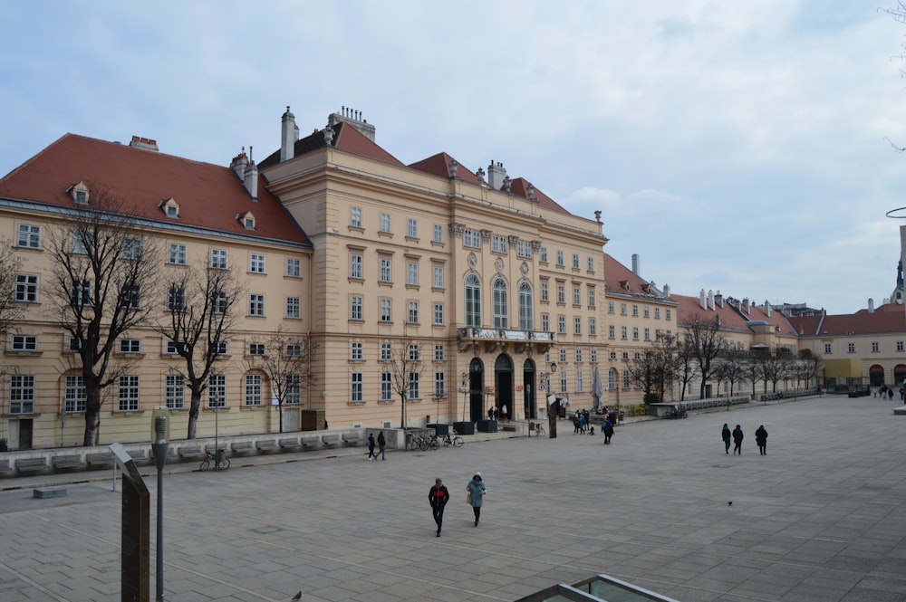 a group of people walking in front of a large building