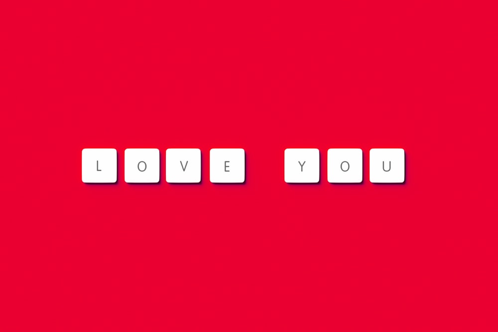 the word love you spelled with cubes on a red background