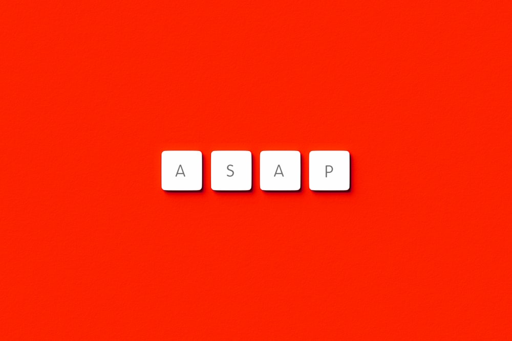 the word asap spelled with scrabble letters on a red background