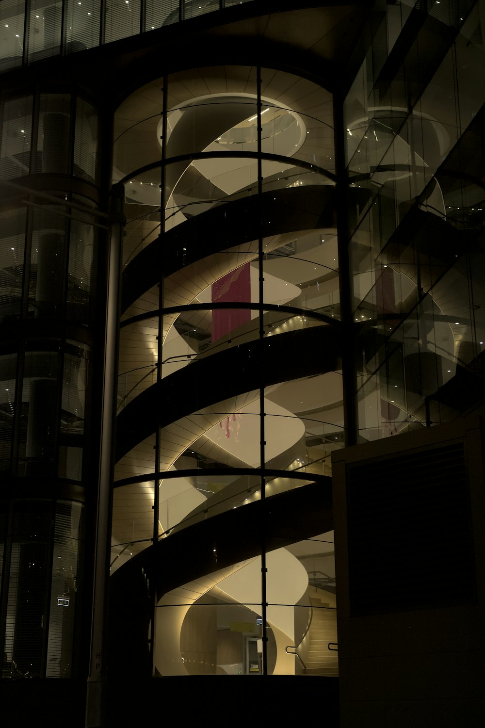 a spiral staircase in front of a building at night