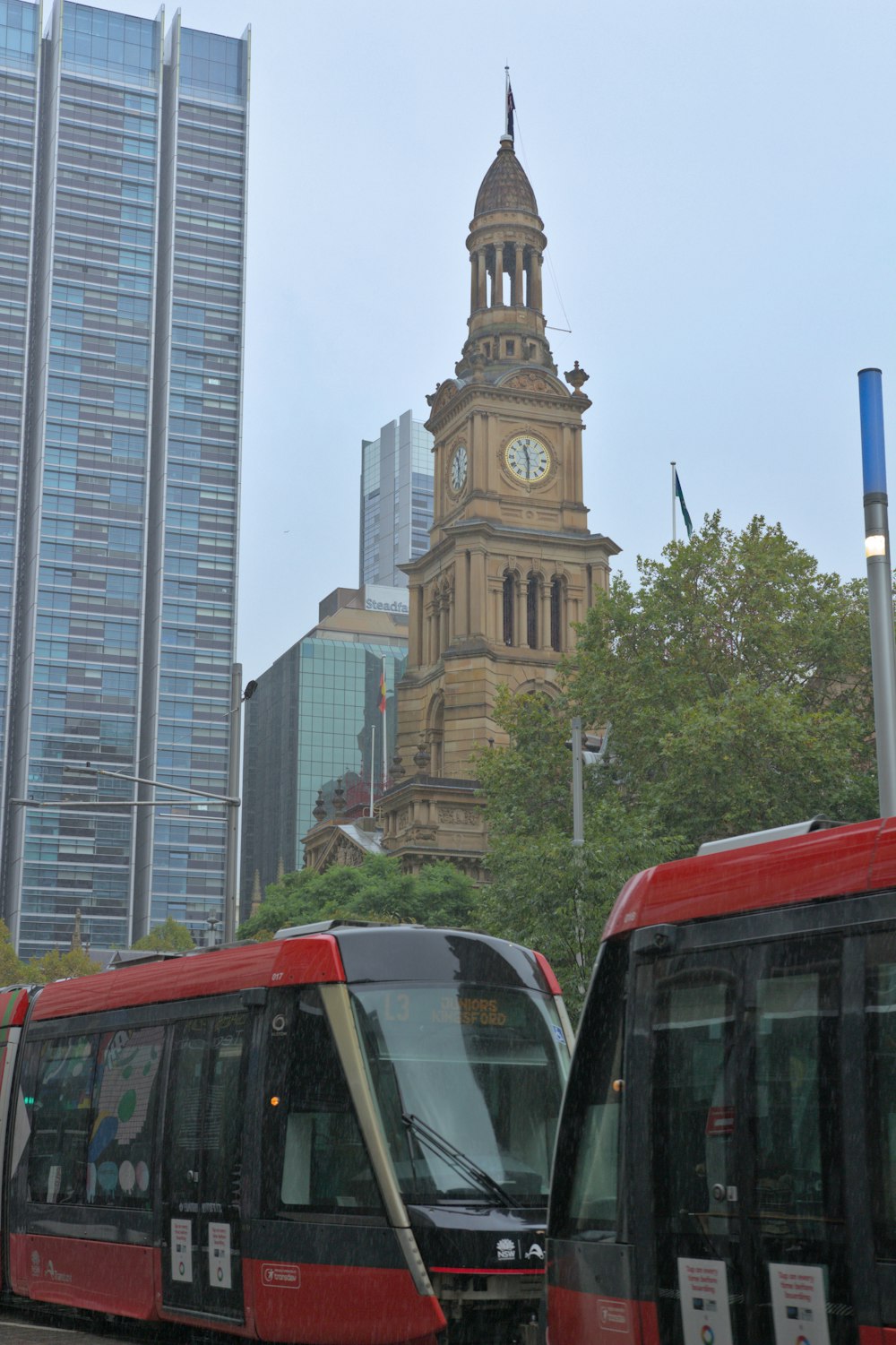 a red and black train some buildings and a clock tower