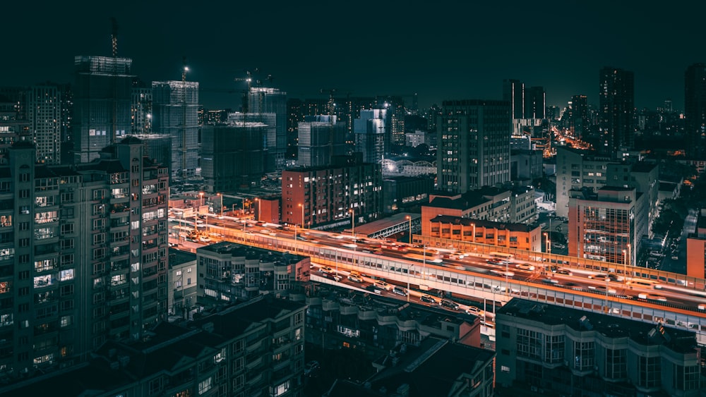 a city at night with a train on the tracks