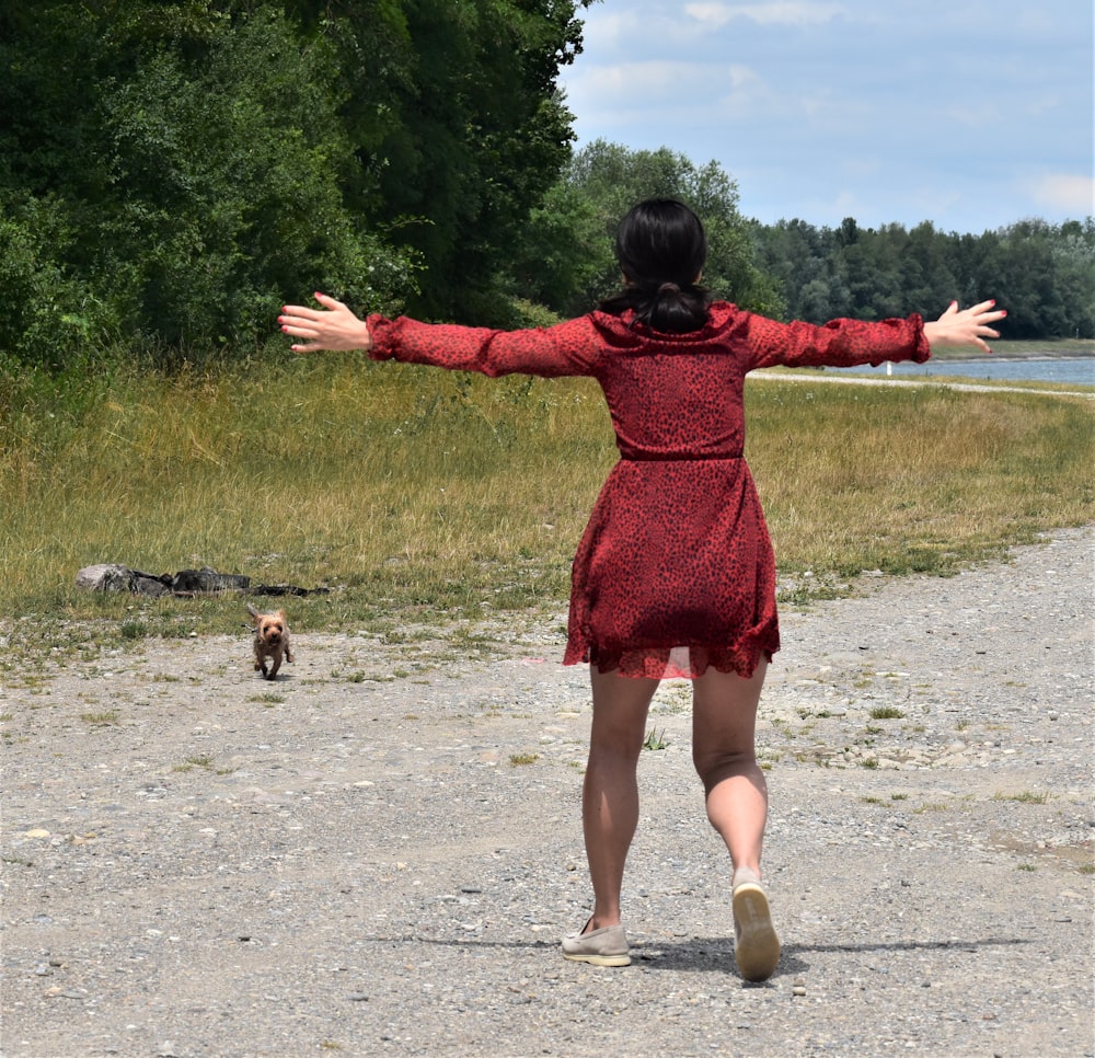 a woman in a red dress is throwing a frisbee