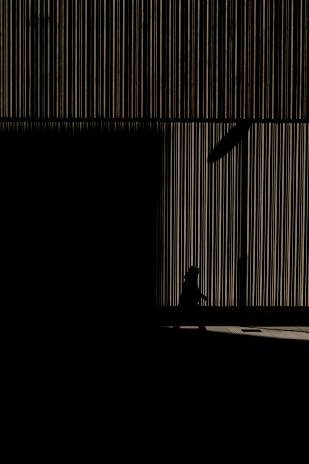 a person sitting on a bench in a dark room