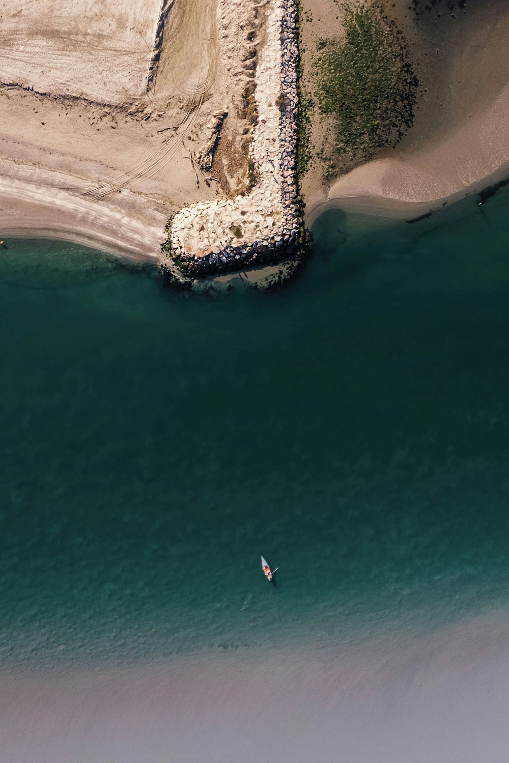 an aerial view of a man in a kayak in the water