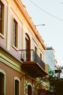 Street view of a quaint building with pastel green and red accents.